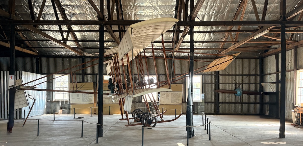Replica Compton Paterson biplane inside the Pioneers of Aviation Museum near Kimberley, with a large wooden aircraft propeller displayed on the far wall.