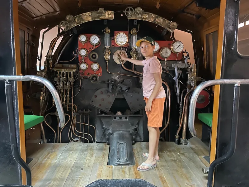 Young visitor exploring the controls inside a preserved steam locomotive cab at the Kimberley Transport Museum. 