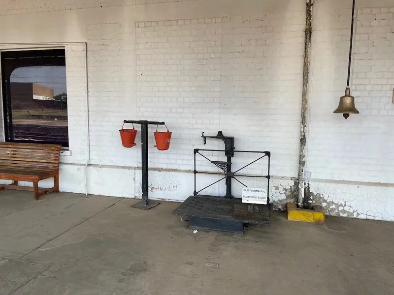 Historic platform weighing scale, railway bell and red fire buckets at Kimberley Railway Station. 