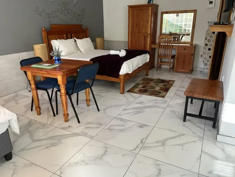 Queen bed and table in Rooms 1 and 2