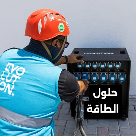 Electrical technician wearing protective equipment while working on a temporary event power distribution board.