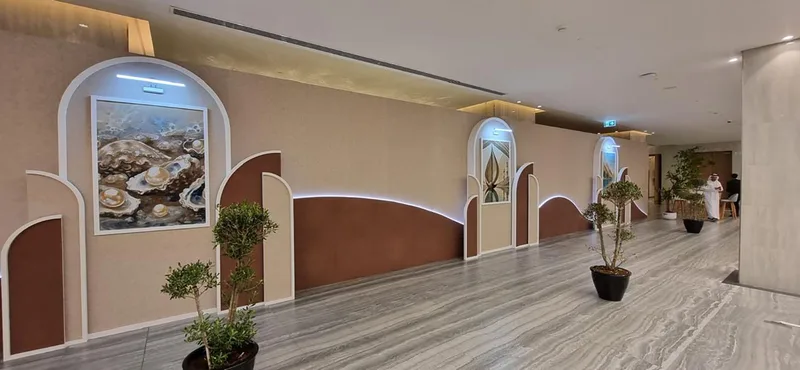 Decorative scenic wall with layered arches, integrated lighting and framed display recesses.