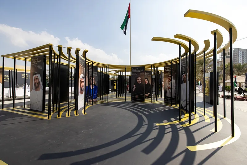 ADNOC 50 Faces gallery installation featuring reflective vinyl scenic finishes in Abu Dhabi.