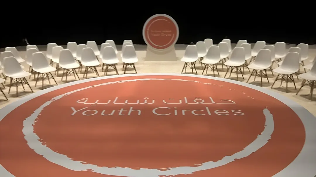 White perimeter stage construction surrounding the central orange branded floor treatment.
