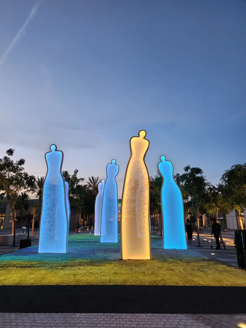 RGBW-lit tulle sculptures creating layered shadows across the sand-filled scenic installation.