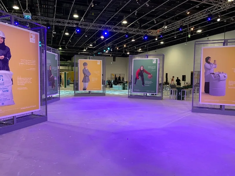 Steel mesh gallery frames supporting large-format employee display graphics.