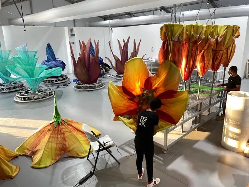 Open orange scenic flower fabricated from mixed wood, metal and textile materials