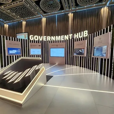 Government Hub scenic wall featuring illuminated vertical fins and recessed digital displays.