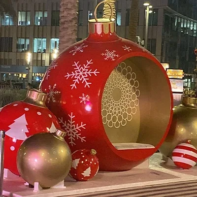 Refurbished giant Christmas bauble seating pod surrounded by decorative ornament props.