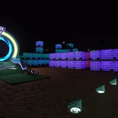 Evolution Scenic nineteenth-hole putting structure with illuminated circular portal and artificial grass.