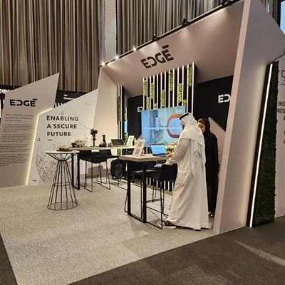 Angular sponsor booth with integrated monitor frames, counters and overhead branding.