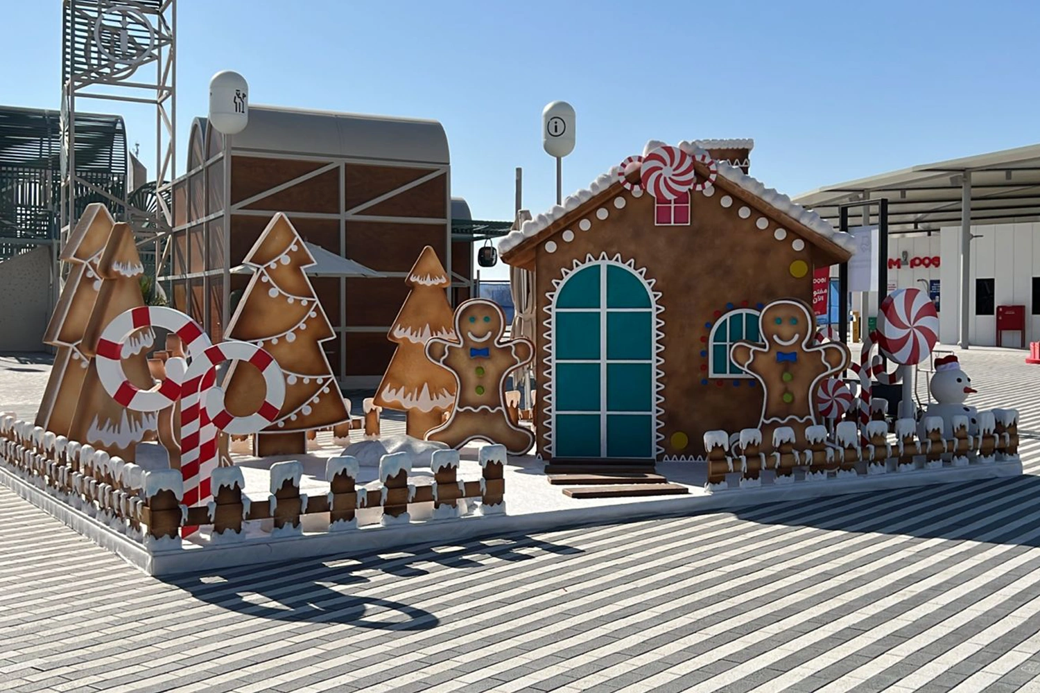 Gingerbread-style Santa’s House with layered confectionery scenic detailing and oversized festive props.