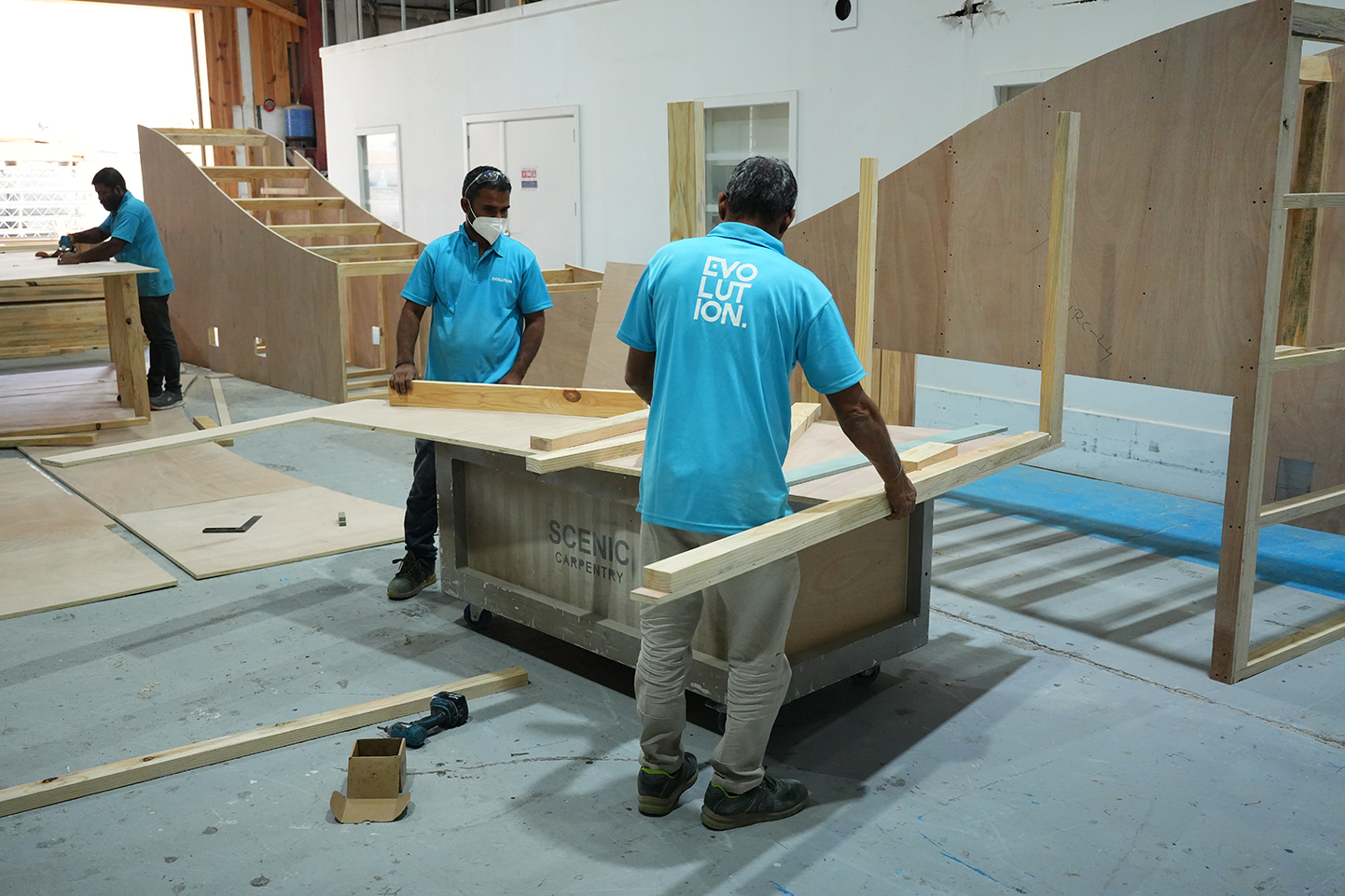 Evolution Scenic carpenters assembling CNC-machined components into a practical scenic structure
