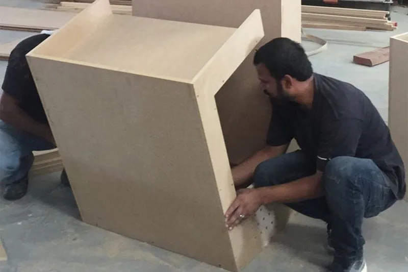 Reception desk carcass under construction with tape measurements checking its maximum transport dimensions.