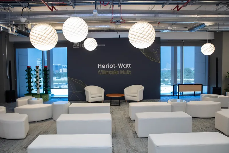 Evolution Scenic carpeted plywood stage with printed fabric backdrop at Heriot-Watt Climate Hub.