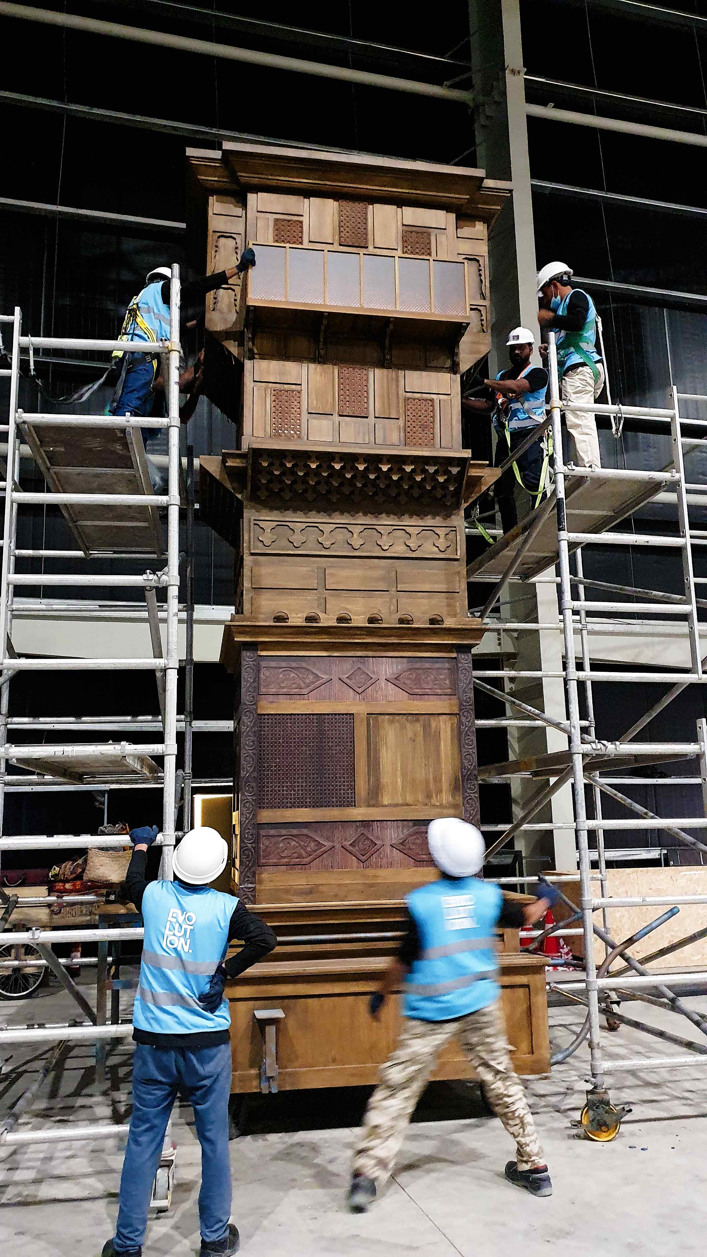 Installer using maintenance hatch during assembly of large scenic structure