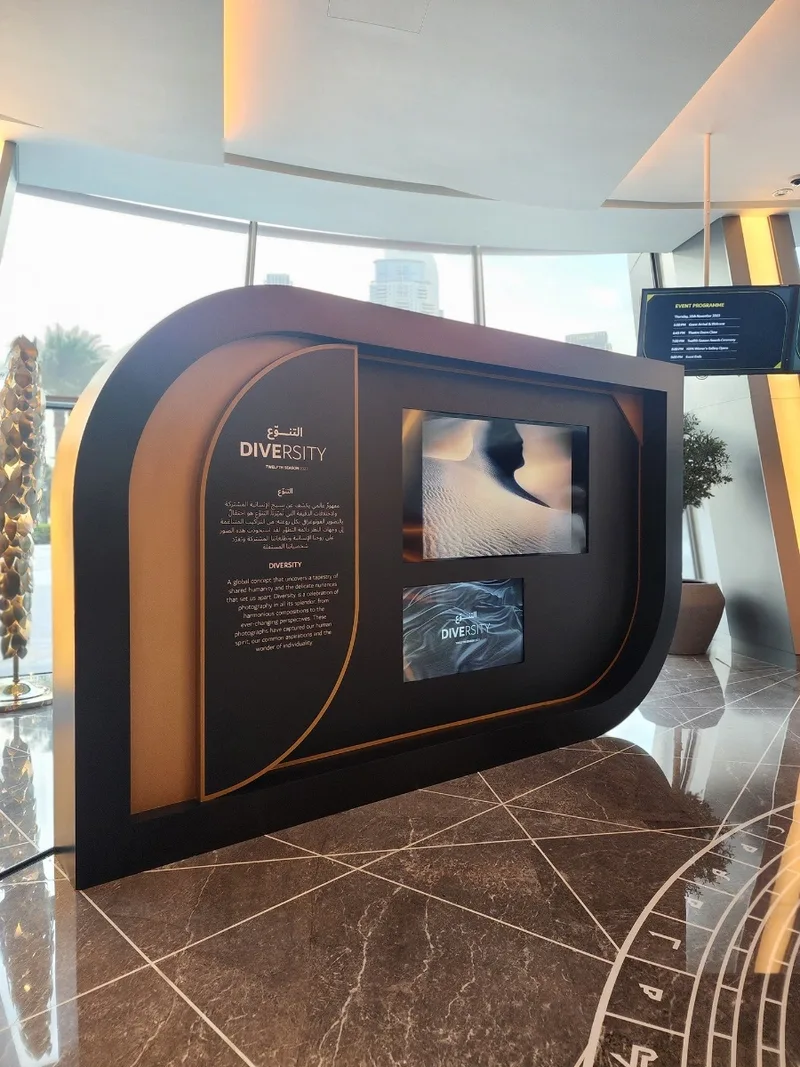 Spray-painted MDF gallery wall with curved corners and inset media display.