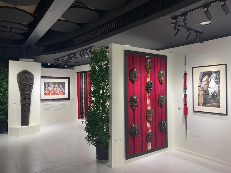 Timber-framed black exhibition walls with integrated graphics and cultural display plinths.