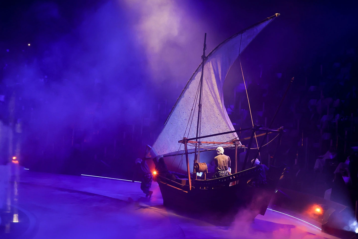 Terhal land-abra scenic boat moving through the live performance under theatrical lighting in Riyadh.
