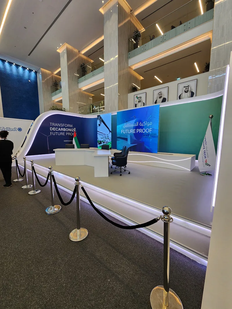 Sponsor booth featuring reflective flooring, LED strips and printed graphic wall treatments.