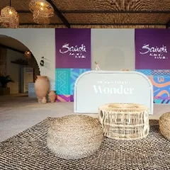 Branded wall graphics and mounted television screens within the temporary hospitality structure.