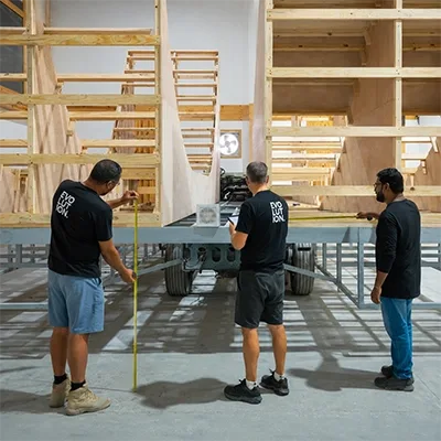 workers-measuring-steel-base-frame.webp