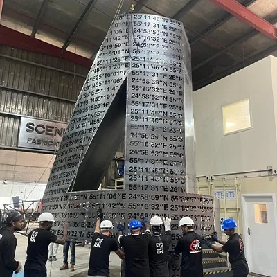 workers-assembling-tall-metal-sculpture.webp