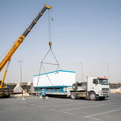Crane lifting temporary event infrastructure during site installation