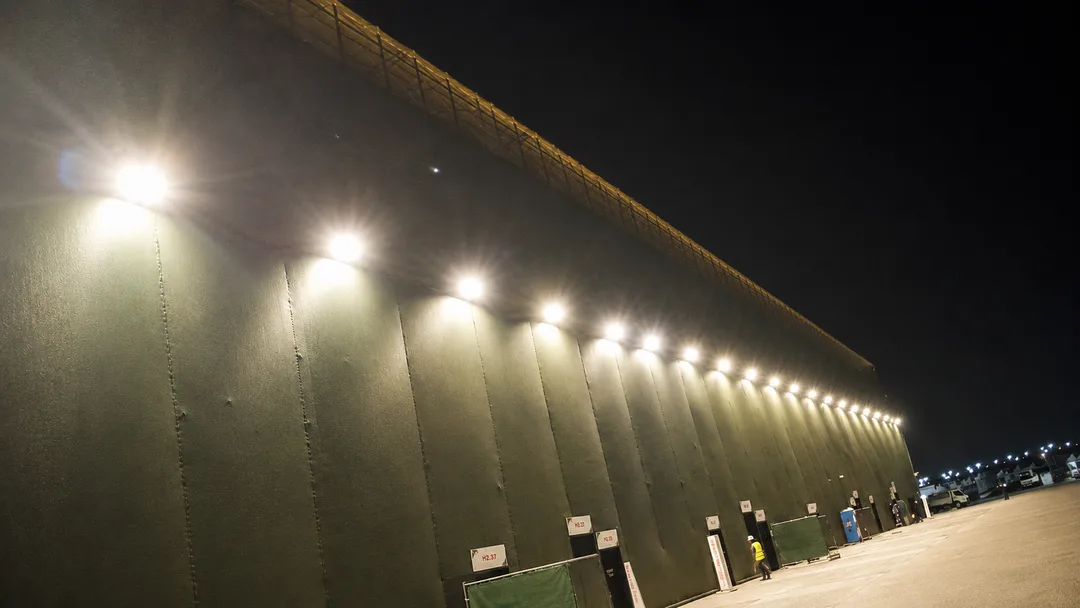 Large temporary event structure illuminated by a continuous line of exterior lights at night in the UAE