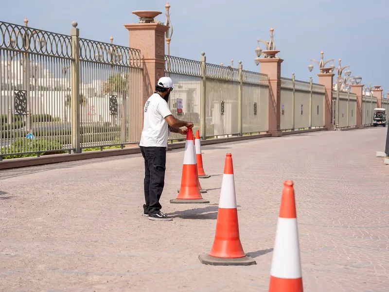 Site operative managing a controlled access route with traffic cones