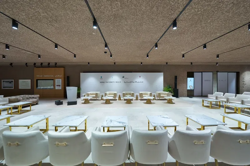 Premium corporate hospitality environment with white lounge seating and low tables arranged for guests.