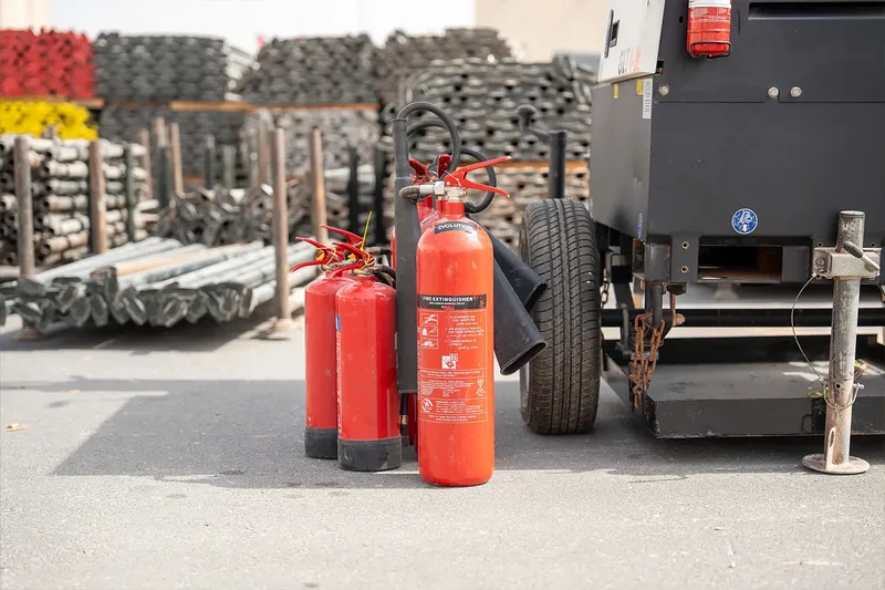 Fire extinguishers positioned beside temporary site equipment