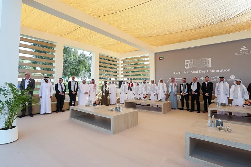 Formal UAE corporate or government hospitality setting with guests gathered in a shaded outdoor pavilion.