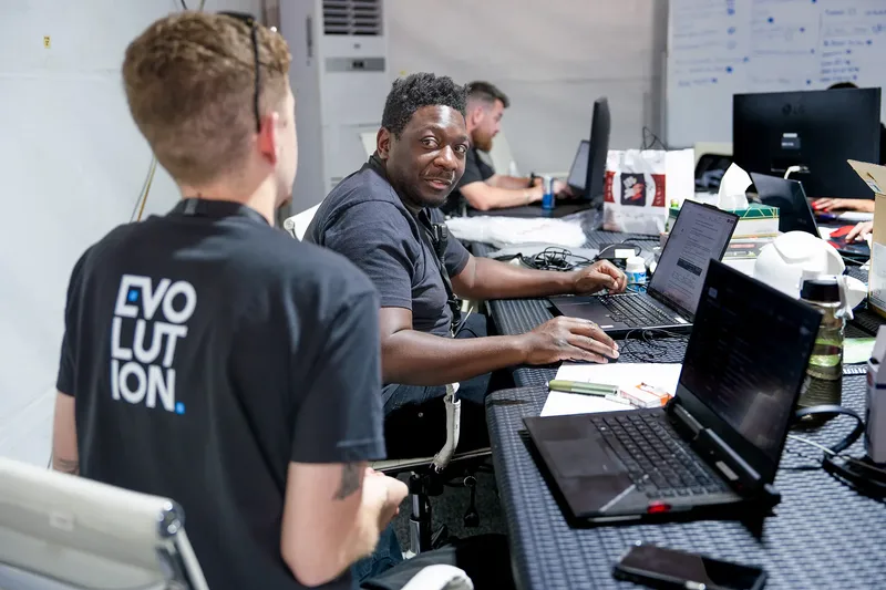 Evolution operations team working from laptops inside a temporary project office and control room.