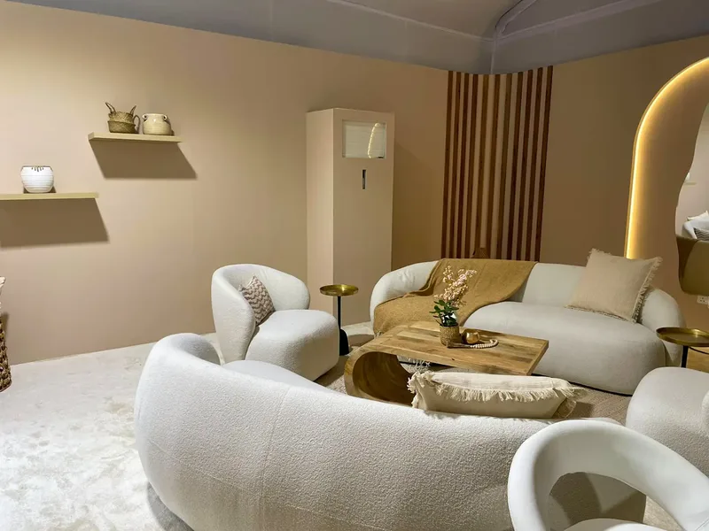 Luxury hospitality lounge with curved white seating, timber finishes and warm integrated lighting.