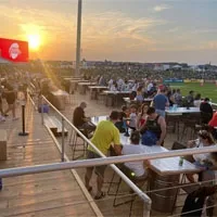 Guests on an outdoor event terrace at sunset