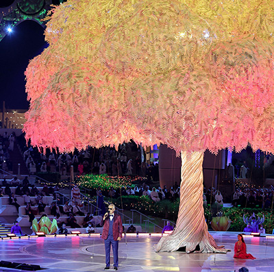Large-scale launch event with illuminated tree installation and live performance