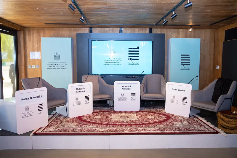 Al Burda Festival breakout room with branded panel stage, lounge seating and cultural event styling