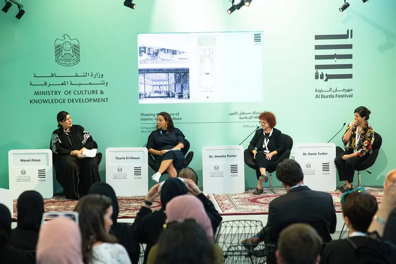 Al Burda Festival panel discussion in Abu Dhabi with speakers, branded stage design and seated audience