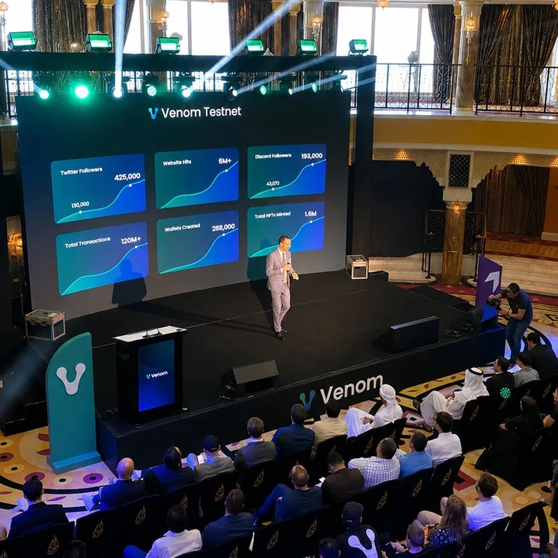 Venom Testnet conference presentation with large LED screens and live audience
