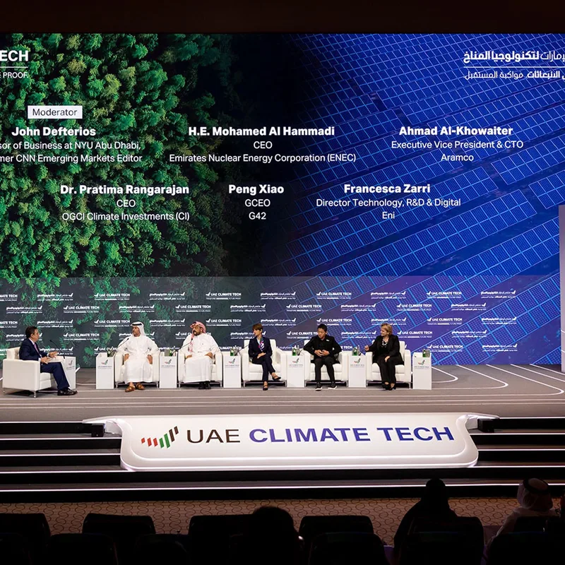 UAE Climate Tech conference panel with senior speakers, large LED backdrop and live audience in Abu Dhabi