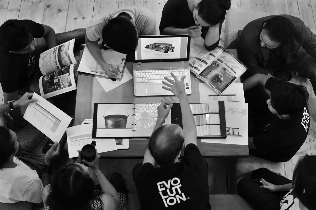 Evolution event planning and production team reviewing technical drawings, design references and material samples during project development
