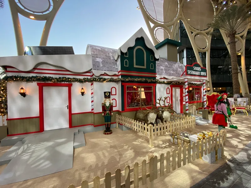 Exterior of Santa’s Sustainable House at Expo City Dubai with festive scenic design and guest entrance