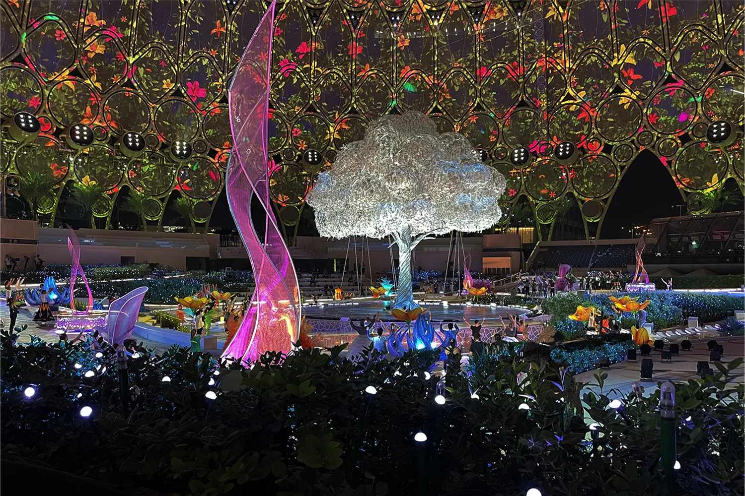 Large-scale live event production with illuminated scenic tree, theatrical lighting and immersive stage design