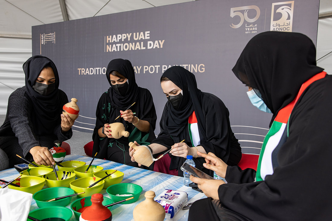 Guests taking part in a traditional pottery painting activity during a UAE National Day corporate event