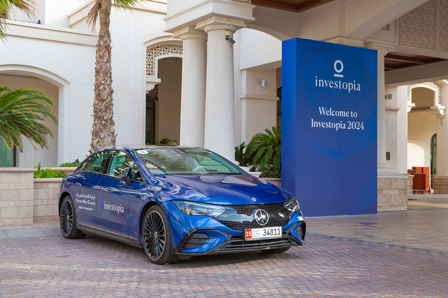 Investopia welcome entrance with branded electric vehicle and freestanding event signage