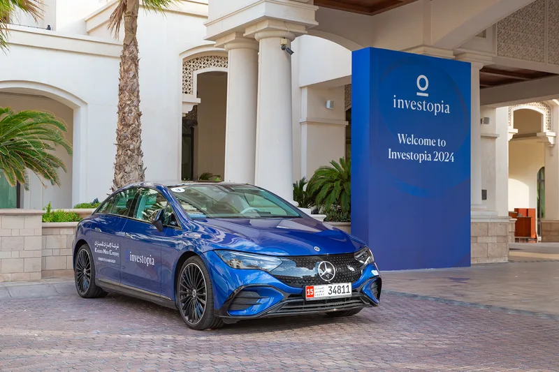 Investopia welcome entrance with branded electric vehicle and freestanding event signage