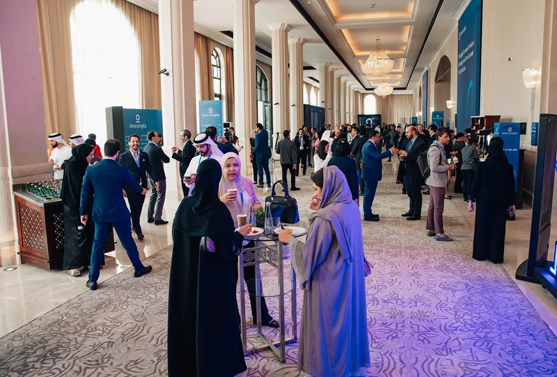 Investopia networking foyer with delegates, hospitality stations and branded directional signage