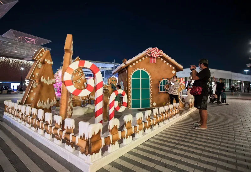 Festive Christmas house installation at Expo 2020 Dubai with themed scenic build, candy-cane details and visitor interaction