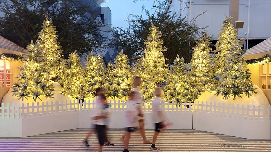 Illuminated Christmas tree installation at Expo 2020 Dubai with festive landscaping and visitor walkway